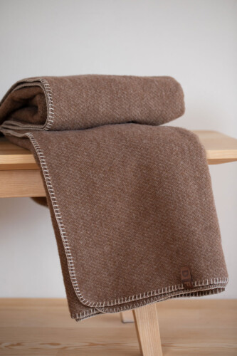MERANO Kuscheldecke in Braun locker über eine Sitzbank drapiert – gemütliches, modernes Wohnzimmer